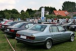 BMW 7er-Reihe auf Pauls Bauernhof; im Hintergrund eine große Forums-Fahne