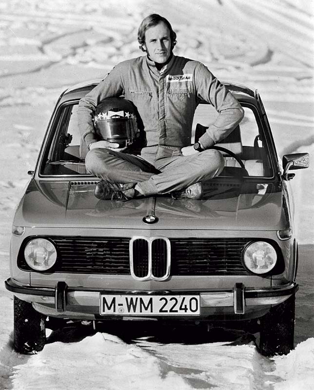 Rennfahrer Hans Stuck auf der Motorhaube des BMW 1502