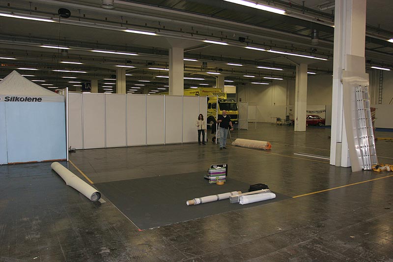 Aufbau des 7-forum.com Messestandes auf der Techno Classica 2008: Der Messestand mit dem ersten Stck verlegten Teppichs