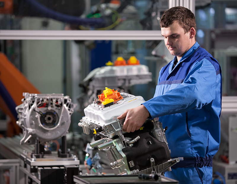 BMW Werk Landshut: Produktion elektrische Antriebssysteme BMW i: Ein Mitarbeiter montiert die Leistungselektronik eines Elektromotors.