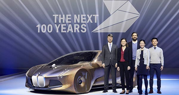 Harald Krüger, Vorsitzender des Vorstands der BMW AG, vier Trainees der BMW Group und das BMW VISION NEXT 100.