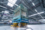 Smart Transport Roboter transportiert Rollcontainer durch Logistikhalle in BMW Group Werk Wackersdorf.