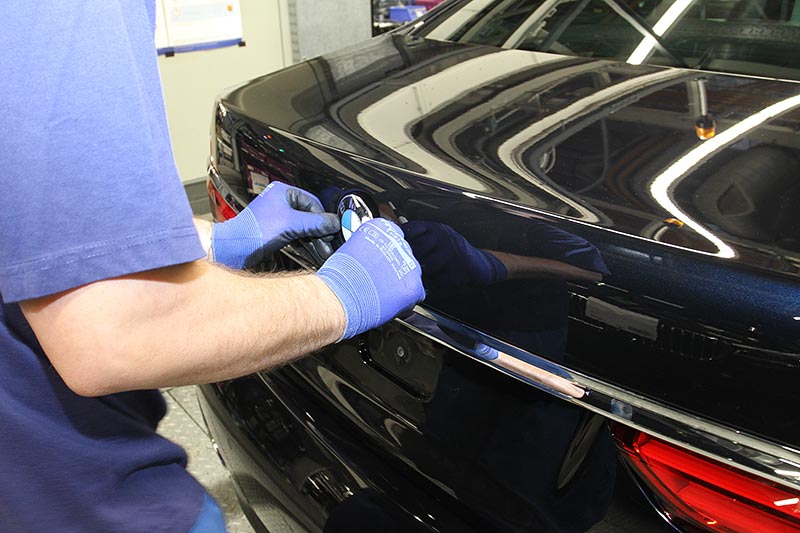 Produktion des BMW 730Ld (G12), Montage des BMW Logos auf der Heckklappe
