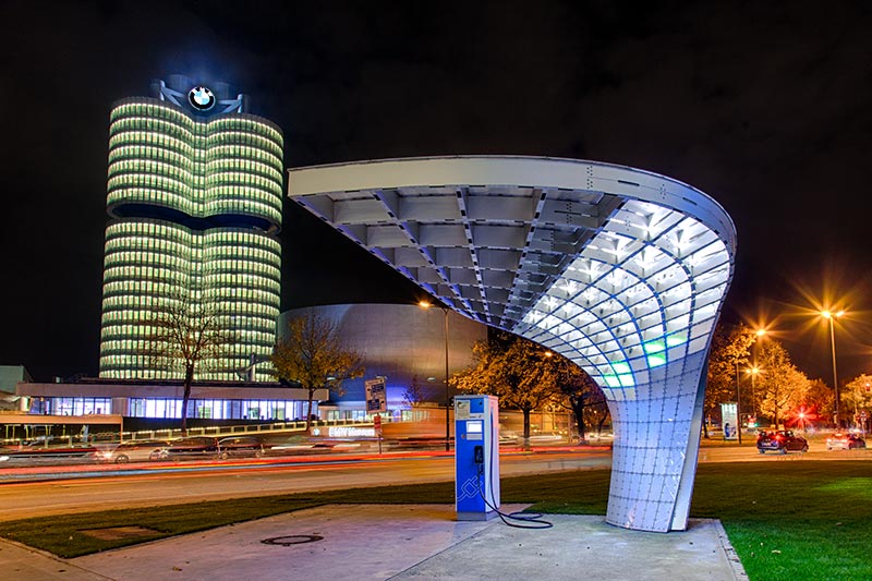 BMW Welt, Elektro-Ladestation mit BMW Konzernzentrale im Hintergrund.