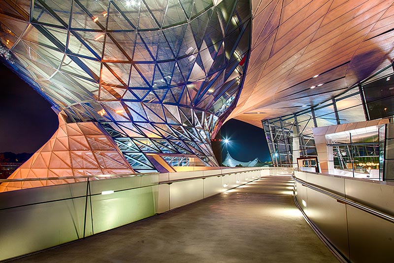BMW Welt am Abend mit seinem Doppelkegel (rechts) und Blick auf das Olympia-Stadion (Mitte)