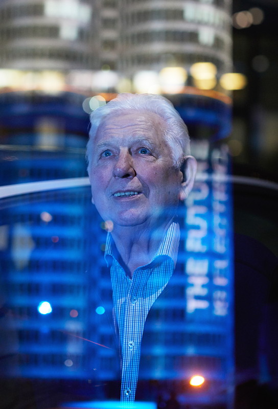 Der 100.000ste Kunde, der in 2017 einen elektrifizierten BMW in Empfang nimmt: Wilhelm Schulten aus NRW. Er blickt auf den illuminierten BMW 'Vierzylinder'.