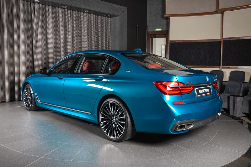 BMW M760Li Individual (G12) in 'Long Beach Blue' in Abu Dhabi, mit BMW M Performance Heckspoilerlippe auf dem Kofferraum.