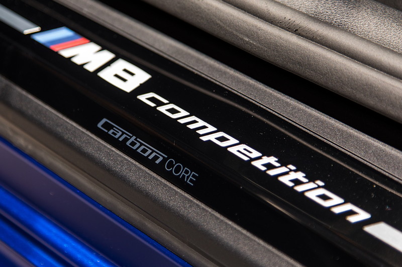 BMW M8 Competition Coup, beleuchtete Einstiegsleiste mit Typ-Bezeichnung.