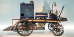 Daimler Motor-Feuerspritze, mit 7 PS starker 2-Zylinder Wasserpumpe, 300 Liter Pumpenleistung. Erste Feuerspritze mit Benzinmotor, noch mit Pferden gezogen.