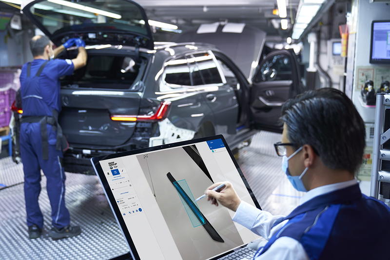 Ein Mitarbeiter markiert Fotos von Einstiegsleisten des BMW 3er, fr den Aufbau einer bildgesttzten KI-Anwendung.
