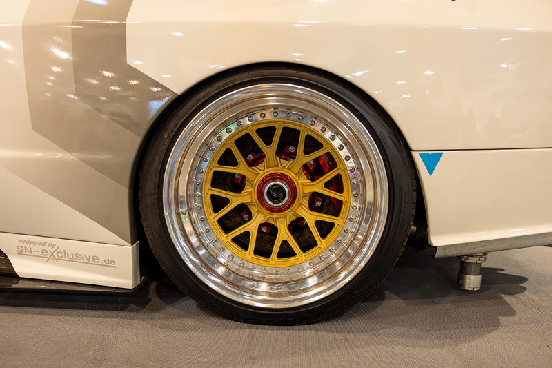 BMW 3er (E30) in der tuningXperience, Essen Motor Show 2022, polierte Felgenbetten, Felgensternen in 'Gold', rot-eloxierter Zentralverschluss