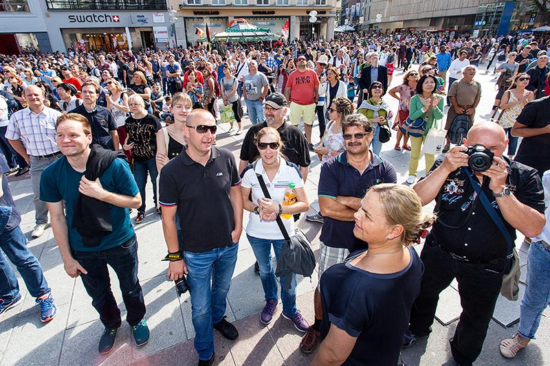 Teilnehmer auf dem Marienplatz beim Verfolgen des Glockenspiels