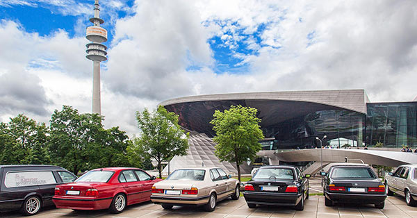 BMW 7er-Reihe vor dem BMW Museum mit Blick auf BMW Welt und Olympiaturm.