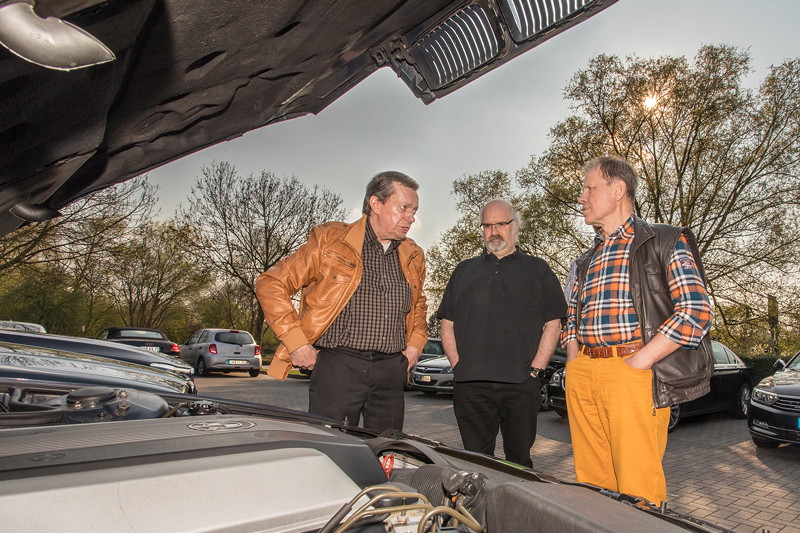 Rhein-Ruhr-Stammtisch im April 2019: Blick unter die Motorhaube des BMW 740i (E38) von Michael ('mikel2002rot', links im Bild)