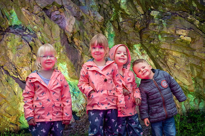 Alyssa, Luna, Zoe und Ben vor dem beleuchteten Kupferbergwer in Sommerkahl am Abend