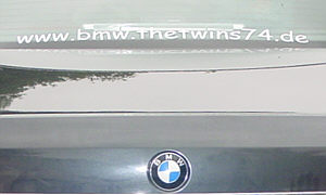 Aufschrift "BMW.TheTwinS74.de" auf der Heckscheibe eines 7ers