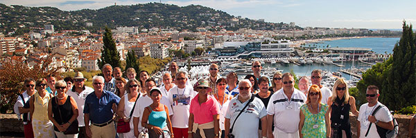 Gruppenfoto der Sternfahrer vor der Notre Dame de l'Esperance in Cannes mit Cannen im Hintergrund