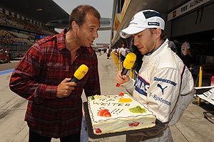 Kai Ebel bergibt Nick Heidfeld eine Torte - im Rahmen der 300. RTL-bertragung eines Formel 1 Rennens
