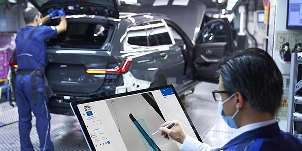 Ein Mitarbeiter markiert Fotos von Einstiegsleisten des BMW 3er, fr den Aufbau einer bildgesttzten KI-Anwendung.