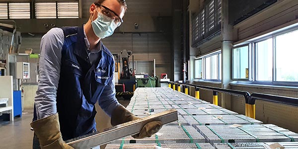 Ein Mitarbeiter im BMW Group Werk Landshut prüft einen Aluminiumbarren, auch „Massel“ genannt.